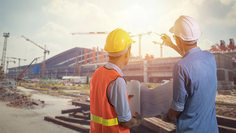 Two construction workers in discussion at building site