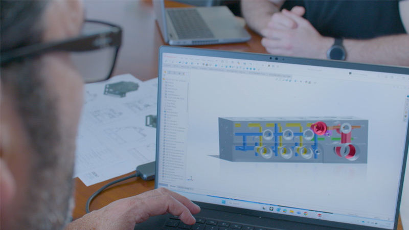 Designer working on 3D model on laptop with SOLIDWORKS