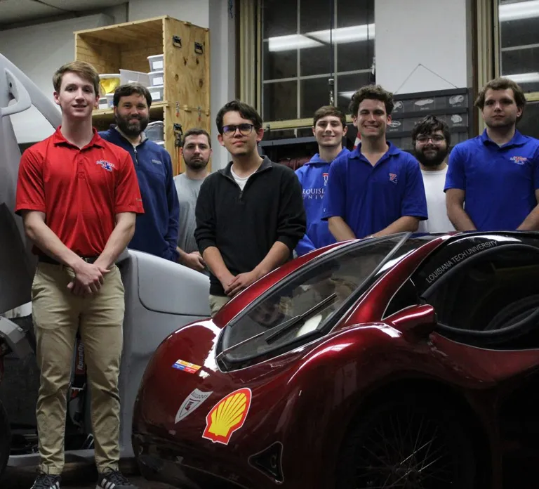 Students standing near student-designed car - SOLIDWORKS sponshs