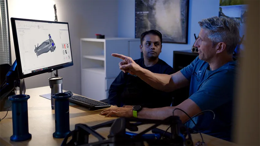 Two Bowhead designers discuss 3D model on screen - SOLIDWORKS